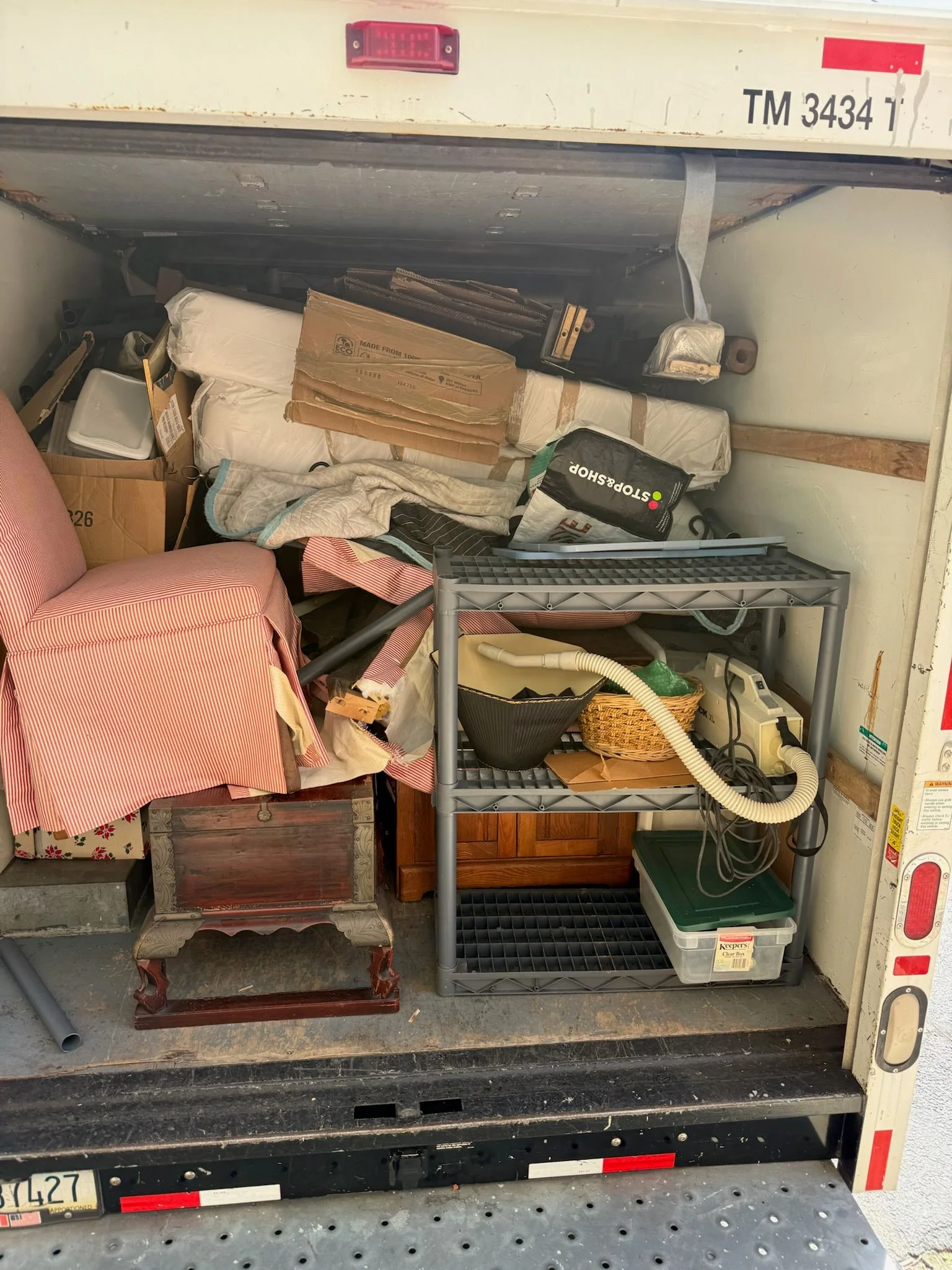 A cleared residential garage in Taunton, Massachusetts with empty floor space after junk removal. Old tools, boxes, and equipment have been hauled away by HS Junk Removal and Property Services.