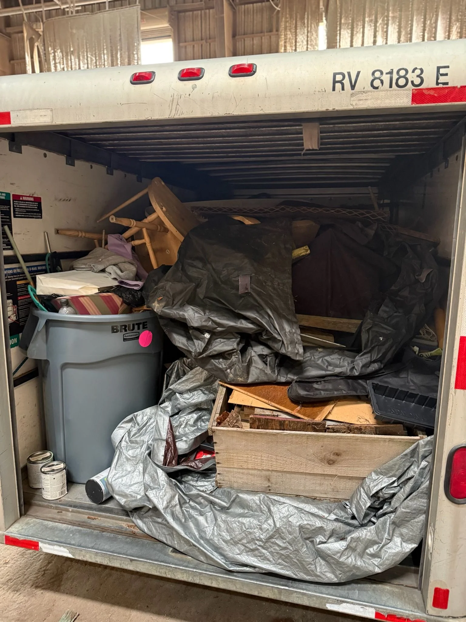 A cleared residential driveway in Taunton, Massachusetts after junk removal, with old appliances and household clutter loaded into a truck bed. The property exterior is visible in the background with no remaining debris on the ground.